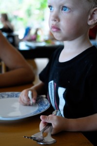 Max håller fast i bestick och tallrik